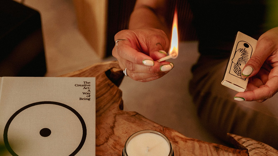 Elegant candle care ritual featuring a wick trimmer and soy candle in a warm minimalist home.