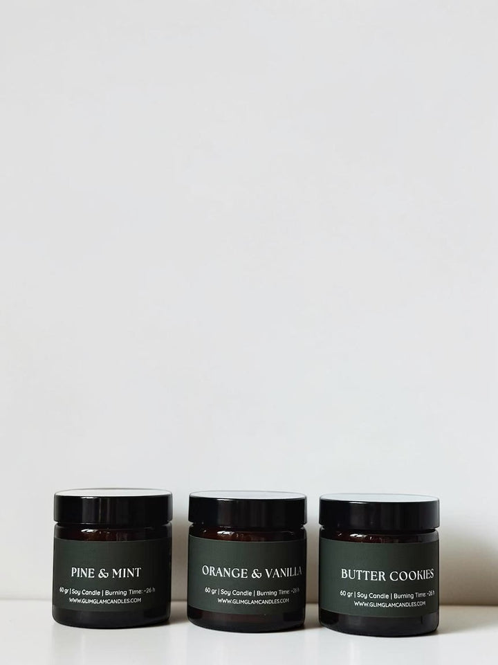Glim & Glam Slow Season gift set of three mini soy candles: Pine & Mint, Orange & Vanilla, and Butter Cookies.