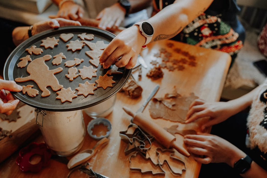 Warm festive corner with sweet people surounded, making gingerbread cookies and soft morning light, perfect for gourmand home fragrances.